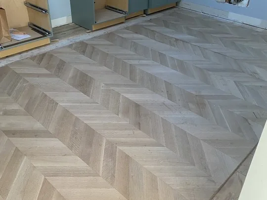 Chevron hardwood floor part way through installation in a New Jersey home