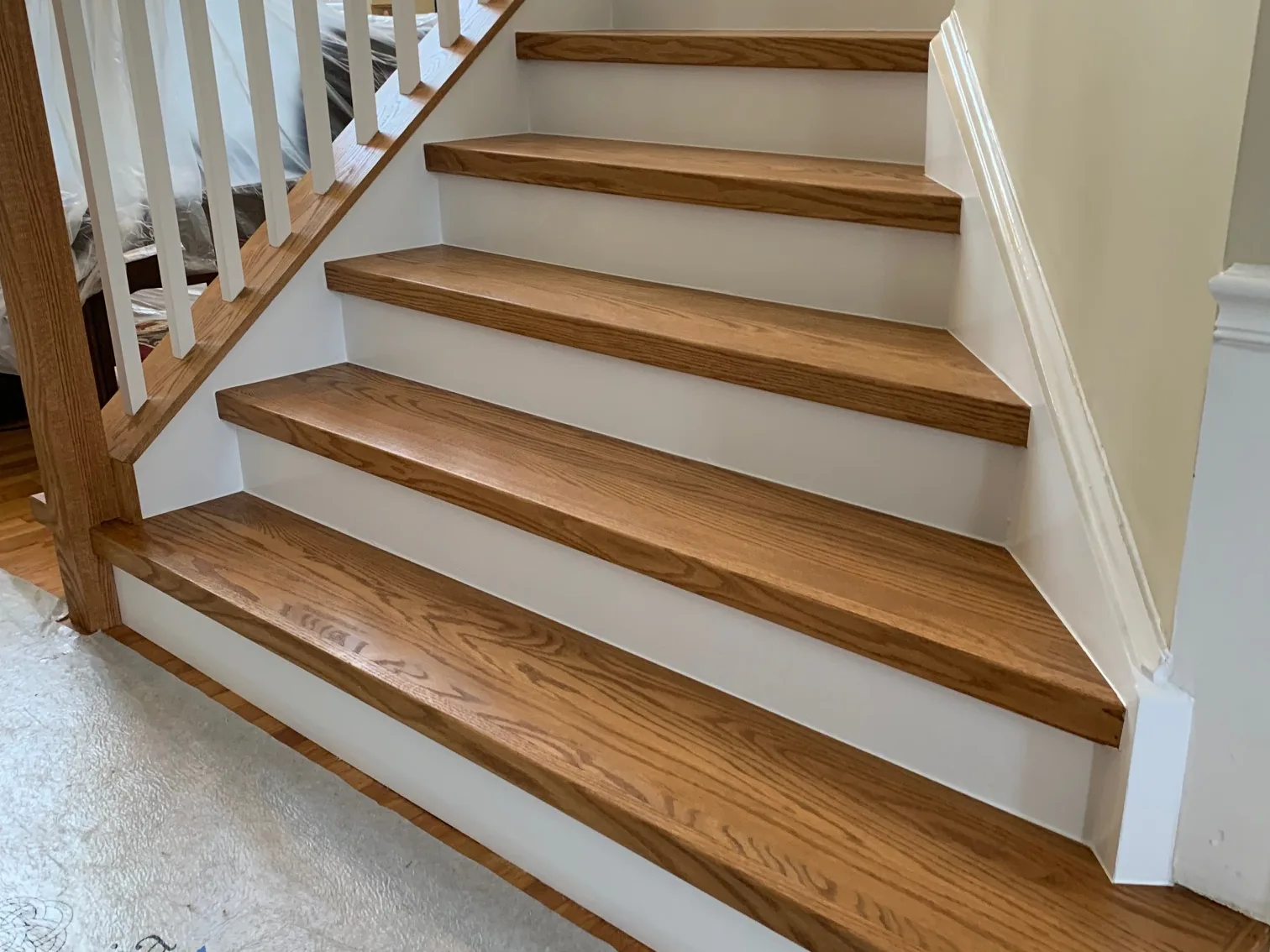 Oak stair treads sanded and refinished against white risers